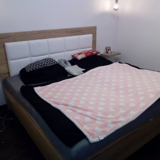 Manželská postel s čalouněným čelem