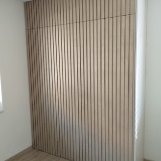 Nábytek na míru s lamelovými dvířky pro dotykové otevírání.