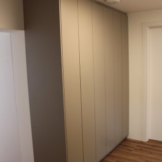 Šatní skříně na míru v béžovém dekoru.