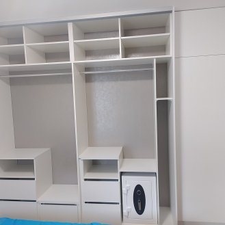 Vestavná skříň na míru v bílé barvě doplněna o samostatnou šatní skříň.