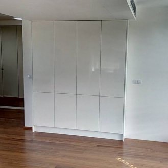 Vestavná skříň s dotykovým otevíráním umístěná do výklenku v budoucí kuchyni. Použit byl bílý korpus a dvířka v bílém lesku.