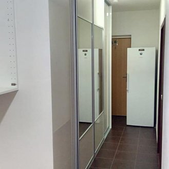 Vestavná skříň v bílém lesku se zásuvkami na dotykové otevírání